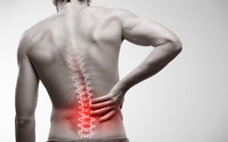 image of a person holding spine in pain