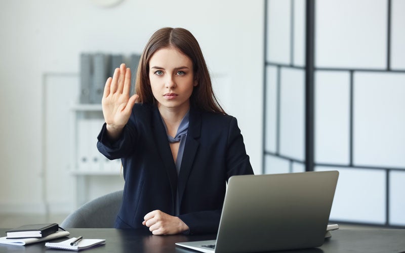 Woman at desk with palm stretched out