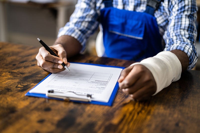 Person with cast on arm filling out paperwork