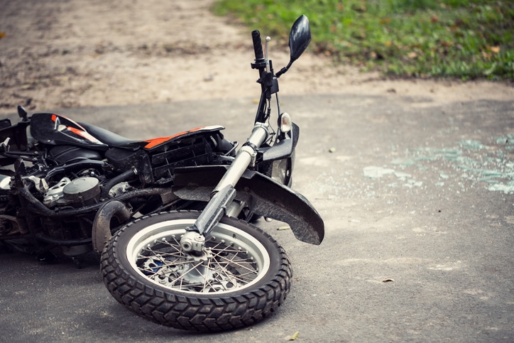 Broken motorcycle on the road after a traffic incident.