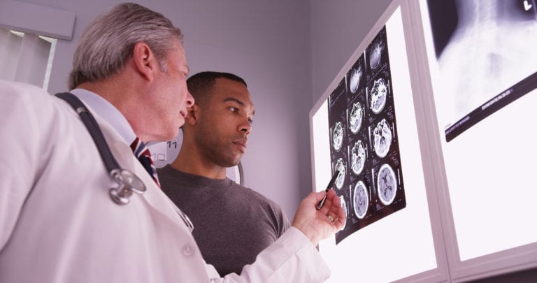 Doctor showing patient scans of brain injury