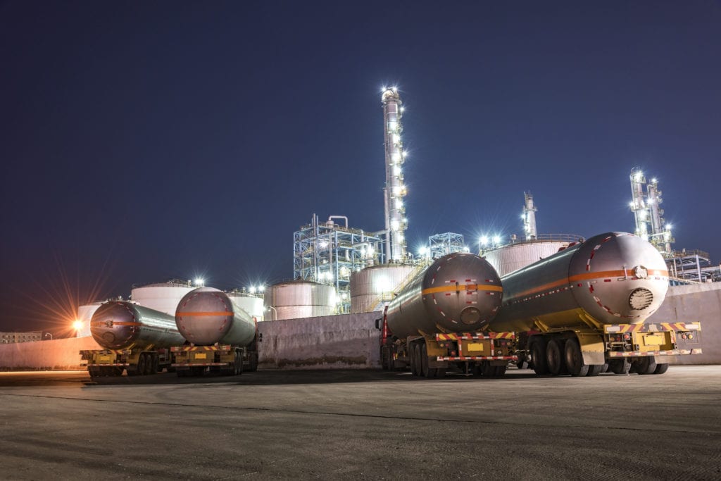 Oil trucks with oil refinery in the background