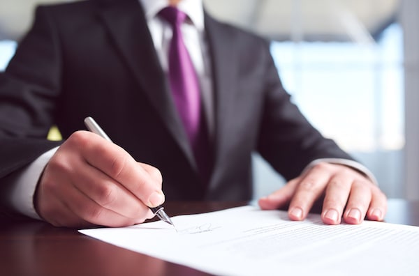 Image of man signing paperwork