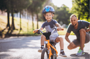 Father teaching his little son to ride a bicycle